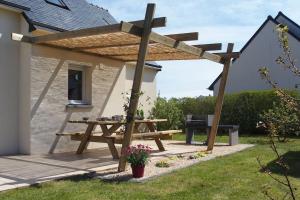 a picnic table and a pergola on a patio at Jolie maison, 8 vacanciers, à 900 m de la mer in Brignogan-Plages