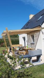 a house with a picnic table and a roof at Jolie maison, 8 vacanciers, à 900 m de la mer in Brignogan-Plages