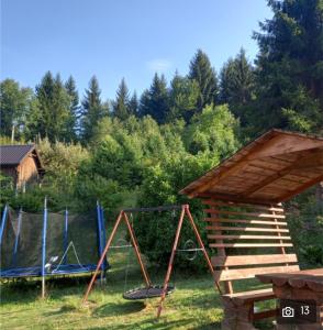 a playground with a swing and a wooden structure at Forest Queen in Travnik