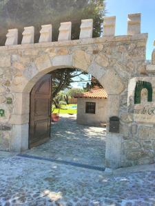 una entrada a un edificio de piedra con puerta en Casas do Rio, en Cossourado