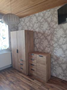 a room with a wooden cabinet and a wall at Berneński Zakątek in Charzykowy