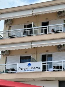 a building with a sign for peoria rooms at Peraia Rooms in Perea