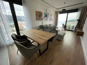 a living room with a wooden table and chairs at APARTMENT IVIL - ELIA RESIDENCE in Becici +17 photos
