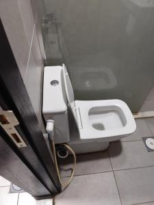 - une salle de bains avec des toilettes blanches dans une cabine dans l'établissement Gentle Breeze Studio 2, à Amman