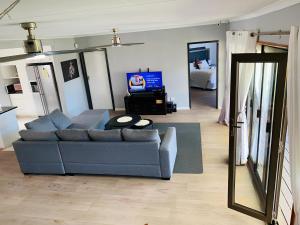 a living room with a blue couch and a television at Bella Hideaway in East London