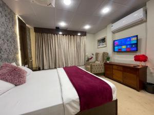 a bedroom with a large bed and a flat screen tv at The Life Style Lodges opp Centaurus Mall in Islamabad