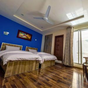 ein Schlafzimmer mit 2 Betten und einer blauen Wand in der Unterkunft Safina Hotel Skardu in Skardu