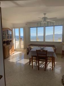 a dining room with a table and chairs and windows at Casa Teresina in Castellabate