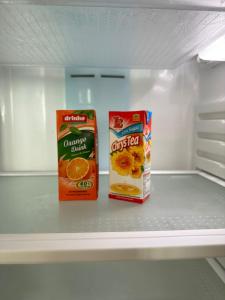 新山的住宿－E Life D Summit Residences With Wifi & Netflix，空冰箱里装有两盒橙汁和橙薯片