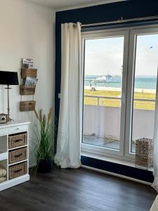 a room with a window with a view of the beach at Hotel Restaurant Ostsee-Anker in Langballig