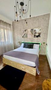 a bedroom with a large bed and a chandelier at Del Regno Holiday House in Pompei +12 photos