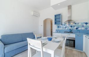 a kitchen and living room with a table and a blue couch at Nice Apartment In Framura With Kitchen in Framura