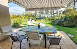 a patio with a table and chairs in a yard at Cozy Home In Locquénolé With Kitchen in Locquénolé +21 photos