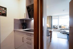uma cozinha com um balcão e uma sala de estar em HOF 306 - Berliner Hof - Seeblick em Scharbeutz