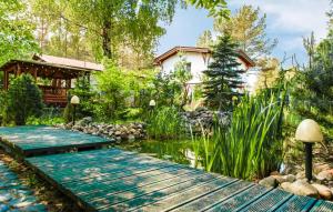 a garden with a wooden bridge over a pond at Nice Home In Swornegacie With Kitchen in Swornegacie