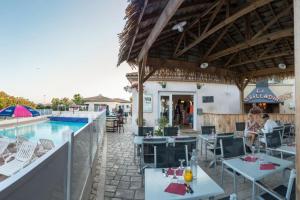 a restaurant with a pool and tables and chairs at Mobil Home in Valras-Plage