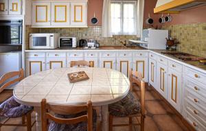 eine Küche mit einem Tisch und einem Tisch und Stühlen in der Unterkunft Stunning Home In Moustiers-Sainte-Marie in Moustiers-Sainte-Marie