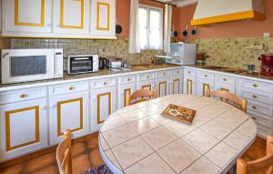 eine Küche mit Tisch und Mikrowelle in der Unterkunft Stunning Home In Moustiers-Sainte-Marie in Moustiers-Sainte-Marie