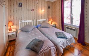2 Bedroom Nice Home In Moustiers-sainte-marie في موستيه سانت ماري: سريرين توأم في غرفة نوم بها مصباحين