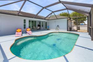 una piscina en el patio trasero de una casa en Pool Table & Game Room, Solar Heated Pool, A Perfect Rest - Villa The Getaway - Roelens, en Cabo Coral