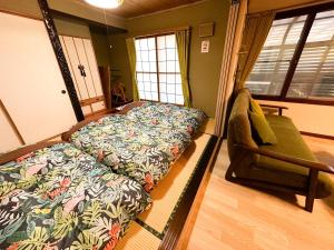 1 dormitorio con cama y sofá en Chano Onsen House 温泉付き en Shiraoi