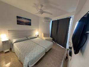 a bedroom with a bed and a flat screen tv at Tamarindo 5 in Benalmádena