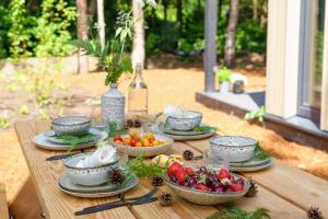 a table with bowls of fruits and vegetables on it at Sød I Tiny house in Epe