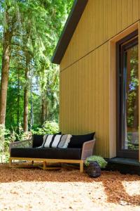 a black couch sitting on the side of a building at Sød I Tiny house in Epe