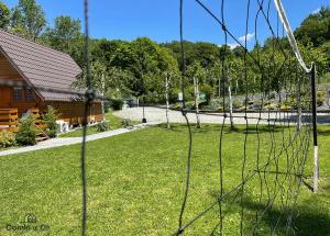 einen Zaun in einem Hof mit einem Haus und Bäumen in der Unterkunft Domki u Oli in Kudowa-Zdrój