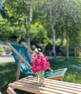 un jarrón de flores rosas sentado en una mesa de madera en Domki u Oli, en Kudowa-Zdrój