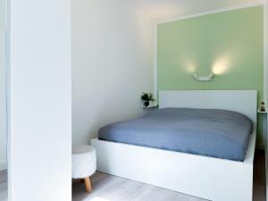 ein Schlafzimmer mit einem weißen Bett mit einem Licht darüber in der Unterkunft Sünnslag Wohnung 054 in Boltenhagen