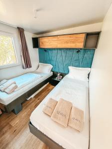 a small room with two beds and a window at SEAYA mobile home - Terra Park SpiritoS in Kolan