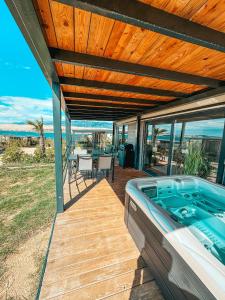a deck with a hot tub on the beach at SEAYA mobile home - Terra Park SpiritoS in Kolan