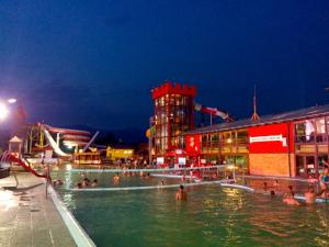 a swimming pool with people in the water at night at Chata 115 Tatralandia in Liptovský Mikuláš