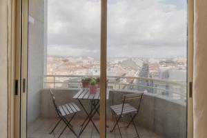 Un balcón con dos sillas y una mesa con vista. en GuestReady - Cozy Luis I Apartment, en Vila Nova de Gaia