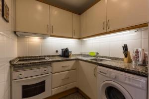 una cocina con estufa horno superior al lado de un lavavajillas en GuestReady - Cozy Luis I Apartment, en Vila Nova de Gaia