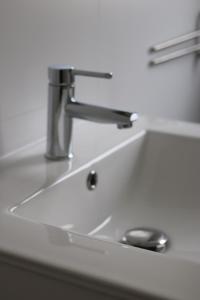 - un évier avec un robinet sur un comptoir blanc dans l'établissement Comfortabel 6p vakantiehuis met laadpaal, à Ewijk