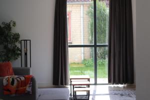 - un salon avec un canapé et une grande fenêtre dans l'établissement Comfortabel 6p vakantiehuis met laadpaal, à Ewijk