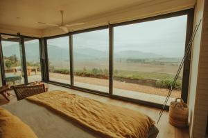 1 dormitorio con ventana grande y cama grande en Palcos de Apalta, en Santa Cruz