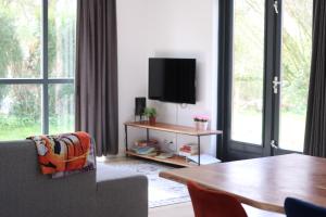 - un salon avec une table et une télévision dans l'établissement Comfortabel 6p vakantiehuis met laadpaal, à Ewijk
