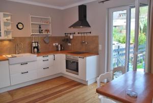 a kitchen with white cabinets and a table and a counter top at Moselschön 2.0 in Alken