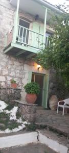 a house with potted plants in front of a door at MELPO in Évyiros