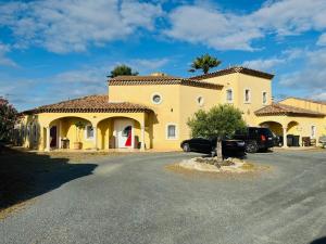 una casa amarilla con un coche aparcado en la entrada en Sud Vacances, en Montels