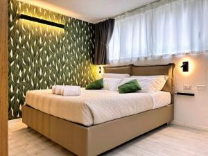 een slaapkamer met een groot bed met groene kussens bij SaliS28 MM3 Affori Centro in Milaan