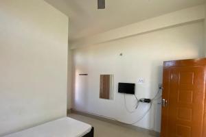 Zimmer mit einer weißen Wand und einer Tür in der Unterkunft Hotel Abhinov in Dibrugarh