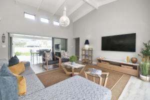 a living room with a couch and a flat screen tv at Cliff Haven in Struisbaai