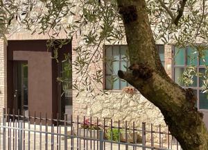 a tree in front of a building with a fence at MP home in Le Grazie
