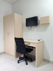 ein Büro mit einem Schreibtisch mit einem Computer und einem Stuhl in der Unterkunft Kost Mandala Residence Official (Syariah) in Jakarta