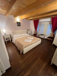 - une chambre avec un grand lit et du parquet dans l'établissement Dimora 4 Spade, à Vérone