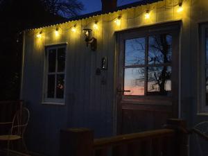 a house with lights on the side of it at night at The Honeypot Shepherds Hut in Ross on Wye